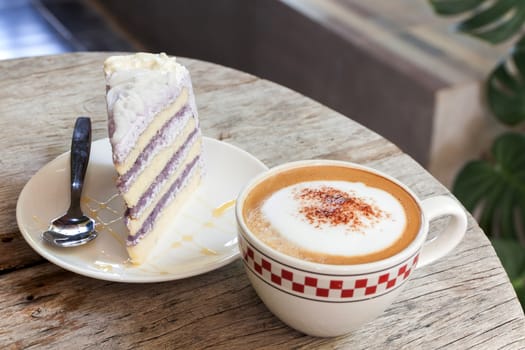 Coffee Break taro cake and Cappuccino coffee on wood table