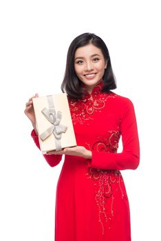 Charming Vietnamese Woman in Red Ao Dai Traditional Dress holding Gift box.