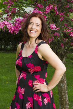 Woman in her forties wearing a summer dress, under a cherry tree