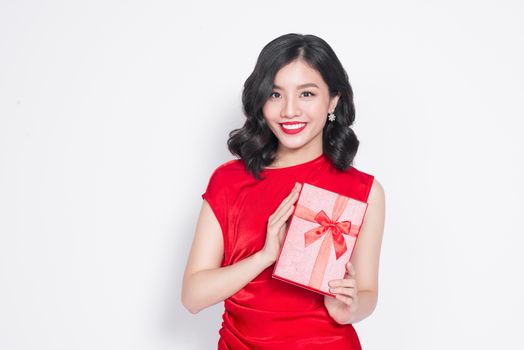 Pretty young glamorous asian woman dressed in red dress with a present