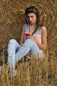 Young woman with her smartphone in field