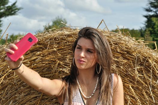 Young woman in field taking a selfie