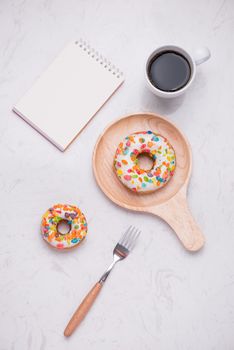 Working desk with dessert and coffee. Cake donuts with a cup of espresso on marble table top. 