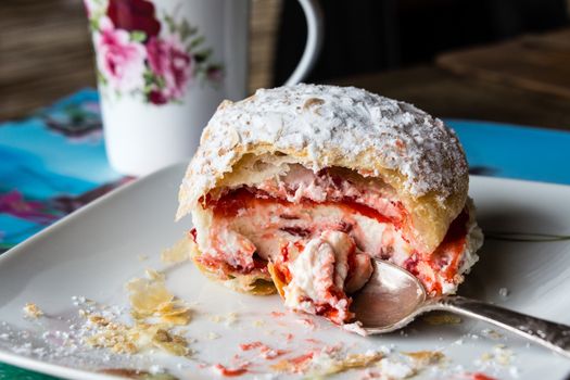 Bun of tender puff pastry with white custard and strawberry jam