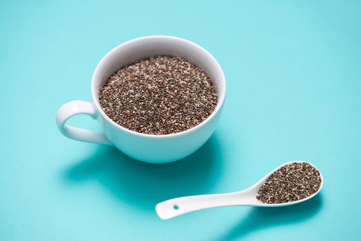 Cup of healthy chia seeds and spoon. Text space.