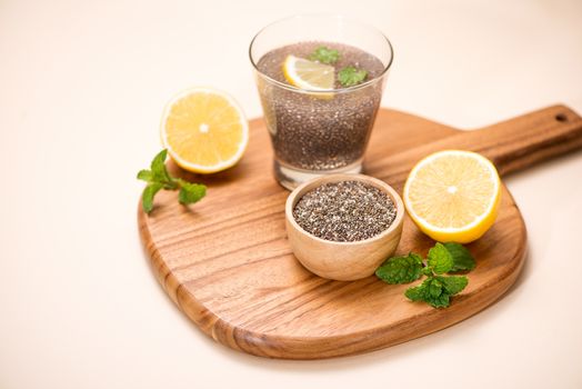 Selective focus of chia seeds drink with water in transparent glass with lemon balm. 