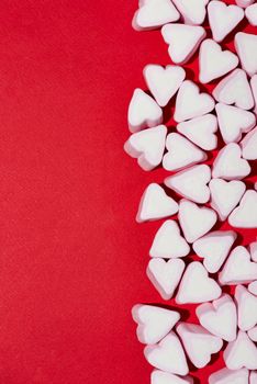 Valentines Day candy hearts marshmallows over red background