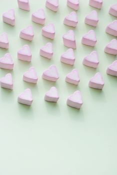 Valentines Day candy hearts marshmallows over green background