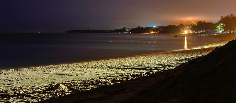 Desaru beach at night. Sea, sand and cloudy sky with bolt and thunder