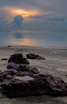 Big red stone near the sea at beautiful dusk sunrise