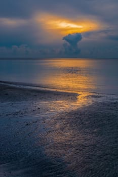 Small creek run into the sea at beautiful sunrise dusk.