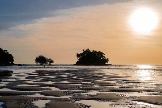 Beautiful colorful sunset near the smal eaxotic island with palms