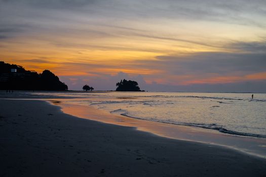 Beautiful colorful sunset near the small exotic island with palms