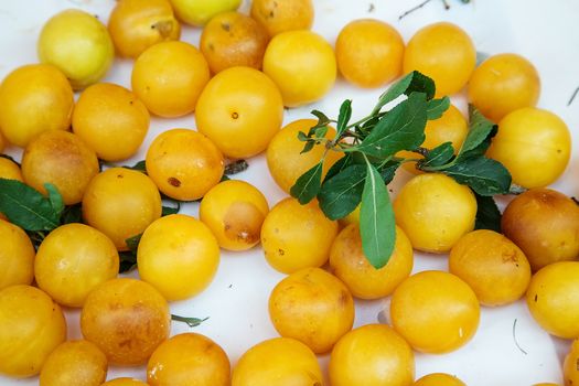 Variety of damaged yellow plum in boxes in traditional rmarket