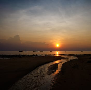 Colorful sunset above the river flowing into the sea