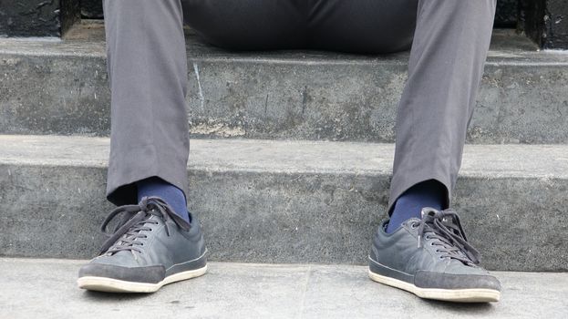 Shoes And Feet Of Man Sitting On Steps