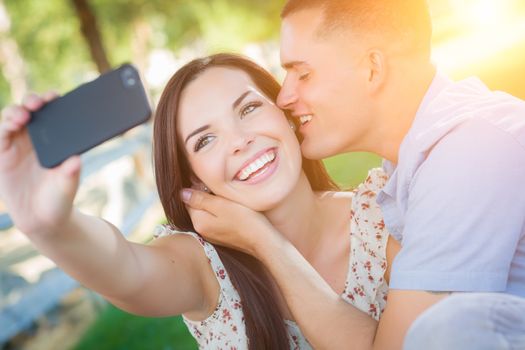 Happy Mixed Race Couple Taking Self Portrait with A Smart Phone in the Park.