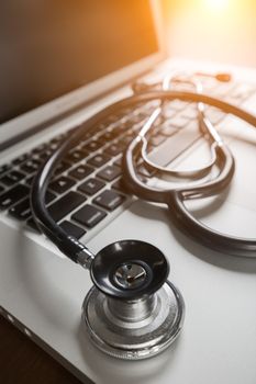 Medical Stethoscope Resting on Laptop Computer Keyboard.