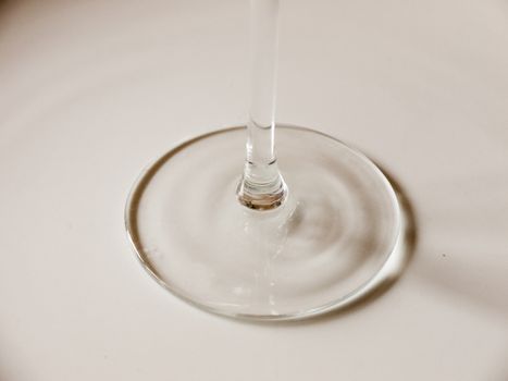 The Bottle of A Wine Glass Looking Like Liquid Being Poured onto a White Background Plate Casting Circle Shadows and Making an Interesting Pattern of Glass Ripples in UK