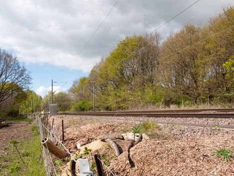 A Railway Track in the Countryside In the UK with No Train and a Barbed Wire Fence and Trees in Background in Spring