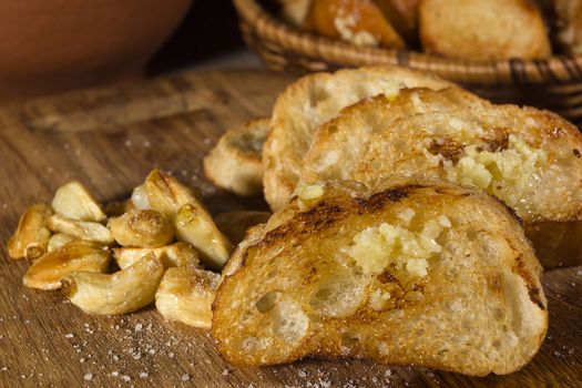 Fried garlic bread and garlic closeup on a wooden board