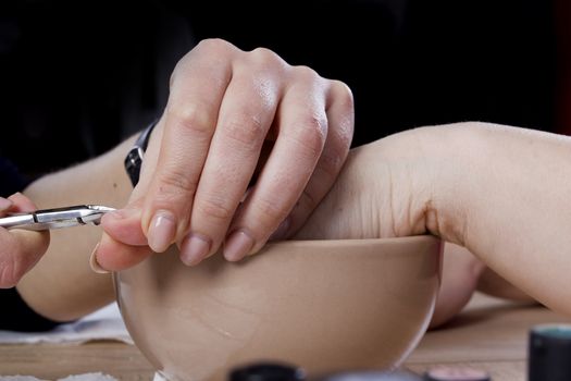 Professional manicure procedure in beauty salon. Hands close up.