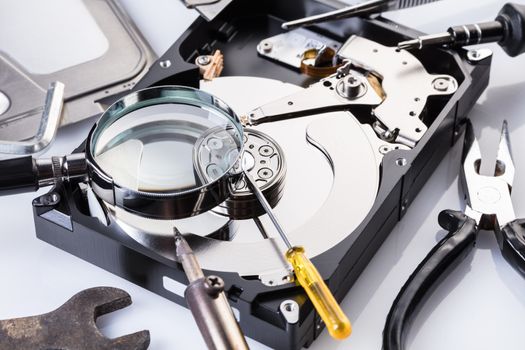 Disassembled computer hard disk and tools close-up