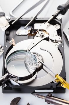 Disassembled computer hard disk and tools close-up