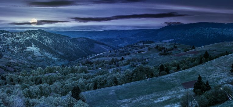 Panoramic rural landscape. forest in mountain rural area. green agricultural field on a hillside. beautiful summer scenery at night in full moon light