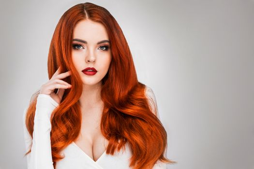 Gorgeous redhead girl with wavy hair beauty studio portrait