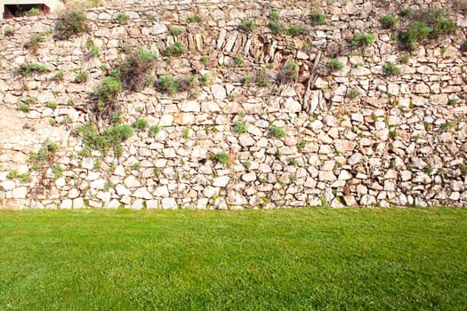 background of stone wall with green grass