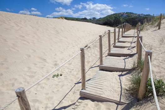Wooden board path way to the sandy beach