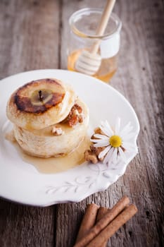 Baked apple with nuts and raisins on a wooden surface