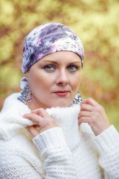 Portrait of beautiful middle age woman patient with cancer wearing headscarf outdoor, hope in healing. She lost her hair