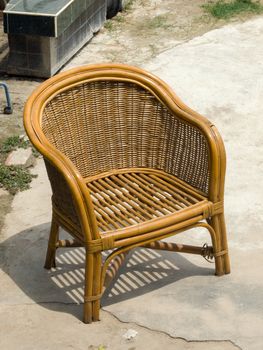 COLOR PHOTO OF RATTAN CHAIR ON CONCRETE GROUND
