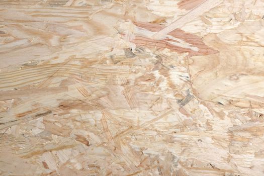 Smooth pale background of OSB - oriented strand board - wooden strips combined with adhesive to make sheet building material.