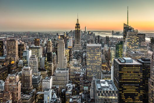 New York City. Manhattan downtown skyline with illuminated Empire State Building and skyscrapers at dusk.