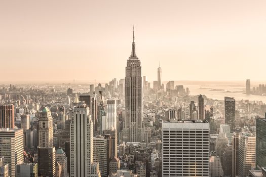 New York City. Manhattan downtown skyline with sun illuminated Empire State Building and skyscrapers at sunset.