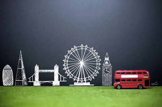 London landmarks drawn on a blackboard with a double decker bus on a grass lawn