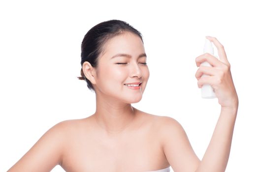 Beautiful asian woman applying spray water on face isolated white background.