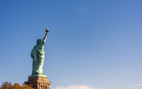 Back of the most famous Statue of Liberty in NY city, USA on a clear blue day