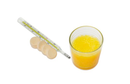 Dissolved effervescent tablet in glass of water, several whole same tablets separately beside and classic mercury medical thermometer on a light background

