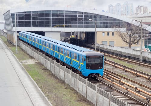 Train of the metro system moving on the overground part of the subway line  
