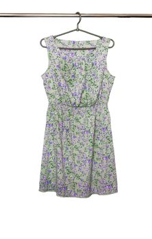 Summer dress with a butterfly pattern hanging on a hanger, isolated.