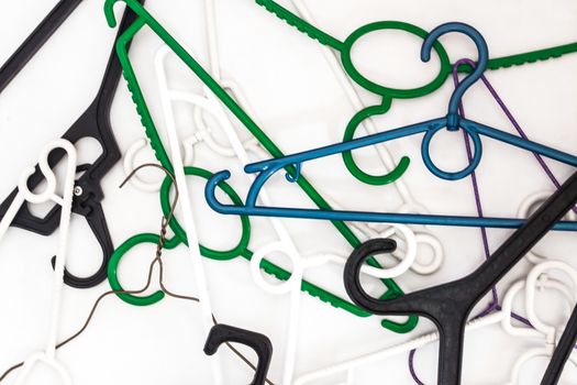 Many hangers of different shapes and colors, top view, white background.