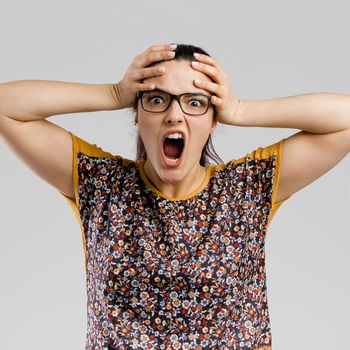 Portrait of woman making a crazy face with hands on head