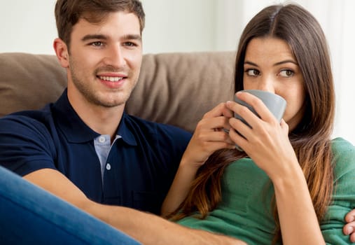 Young couple on the sofa drinking coffee