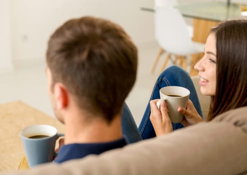 Young couple on the sofa drinking coffee