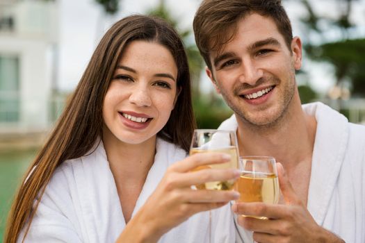 Young couple  in a luxury hotel tasting a glass of white wine