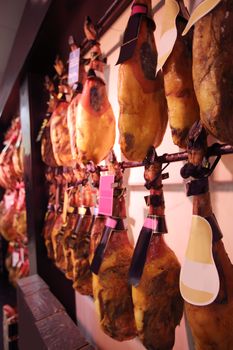 Traditional spanish jamon legs on showcase in store